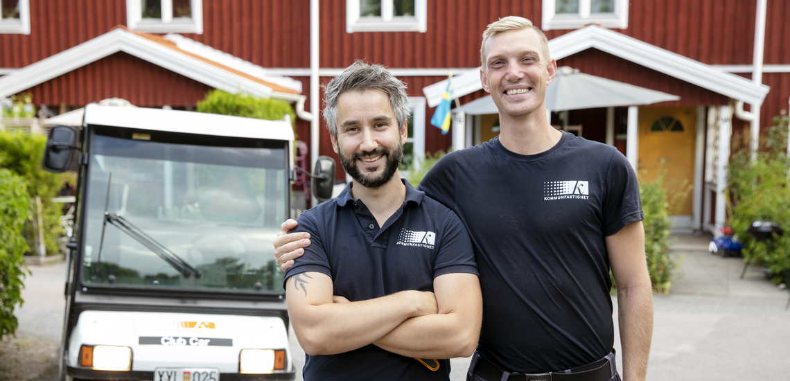 Bild på två Kfast medarbetare som glatt håller om varandra i ett av våra bostadsområden.