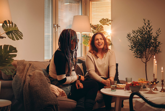 Två kvinnor som sitter och pratar i ett vardagsrum.