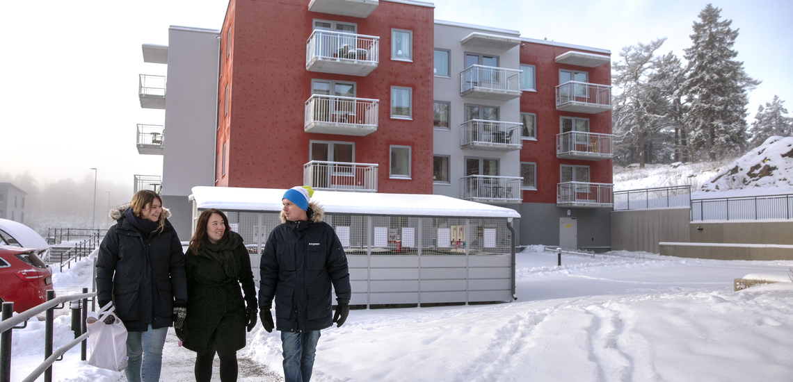 tre personer som promenerar i ett bostadsområde