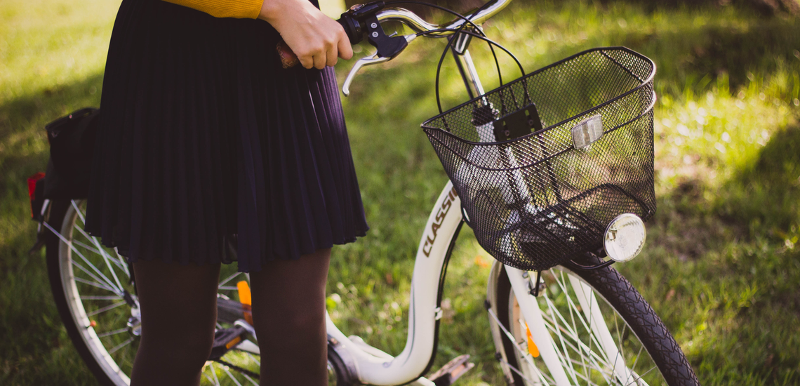 kvinna som leder en cykel