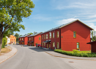 Röda trä fastigheter en grön sommardag i Torshälla.