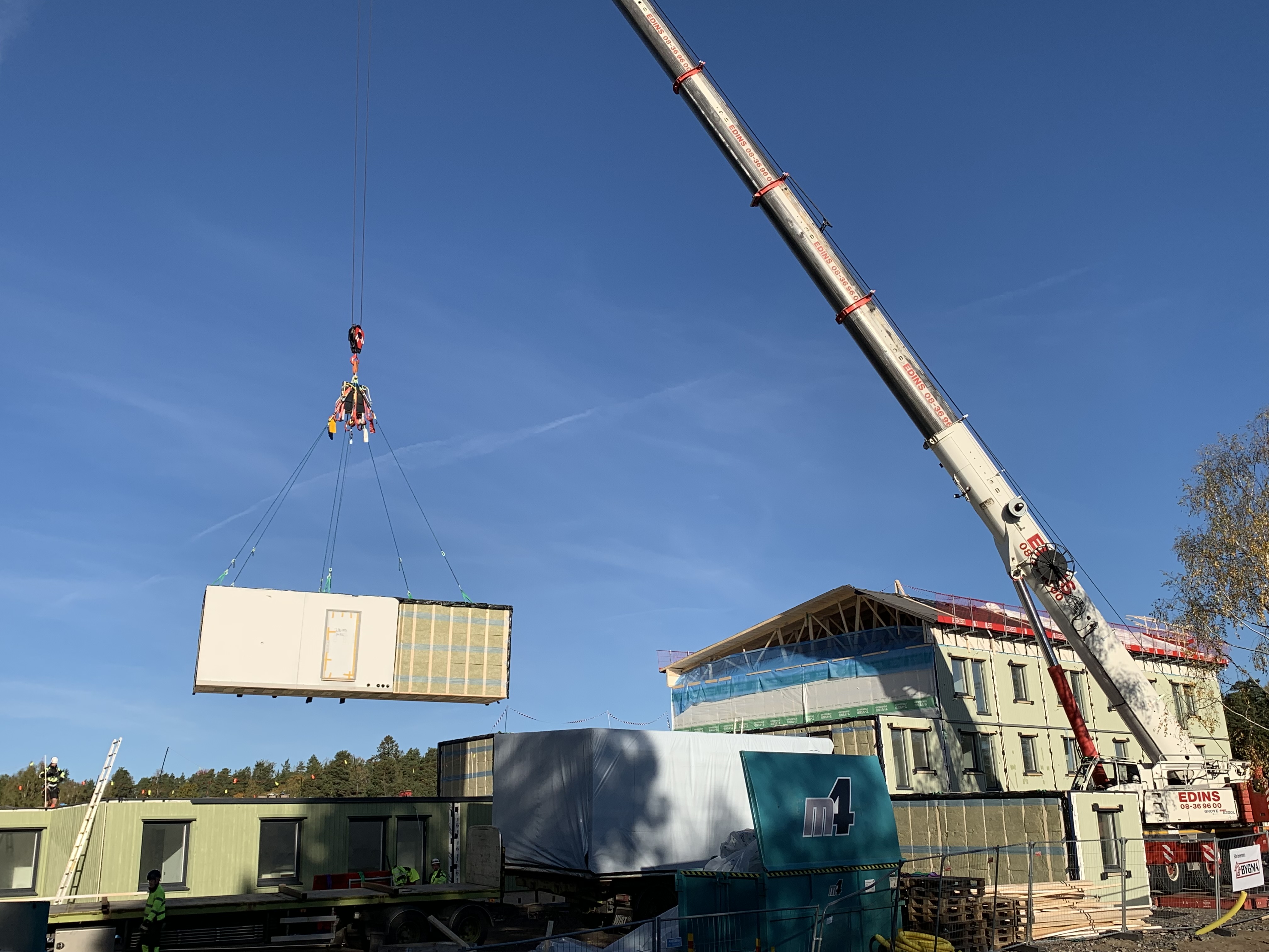 Husmodul lyfts på plats med hjälp av en gigantisk lyftkran.