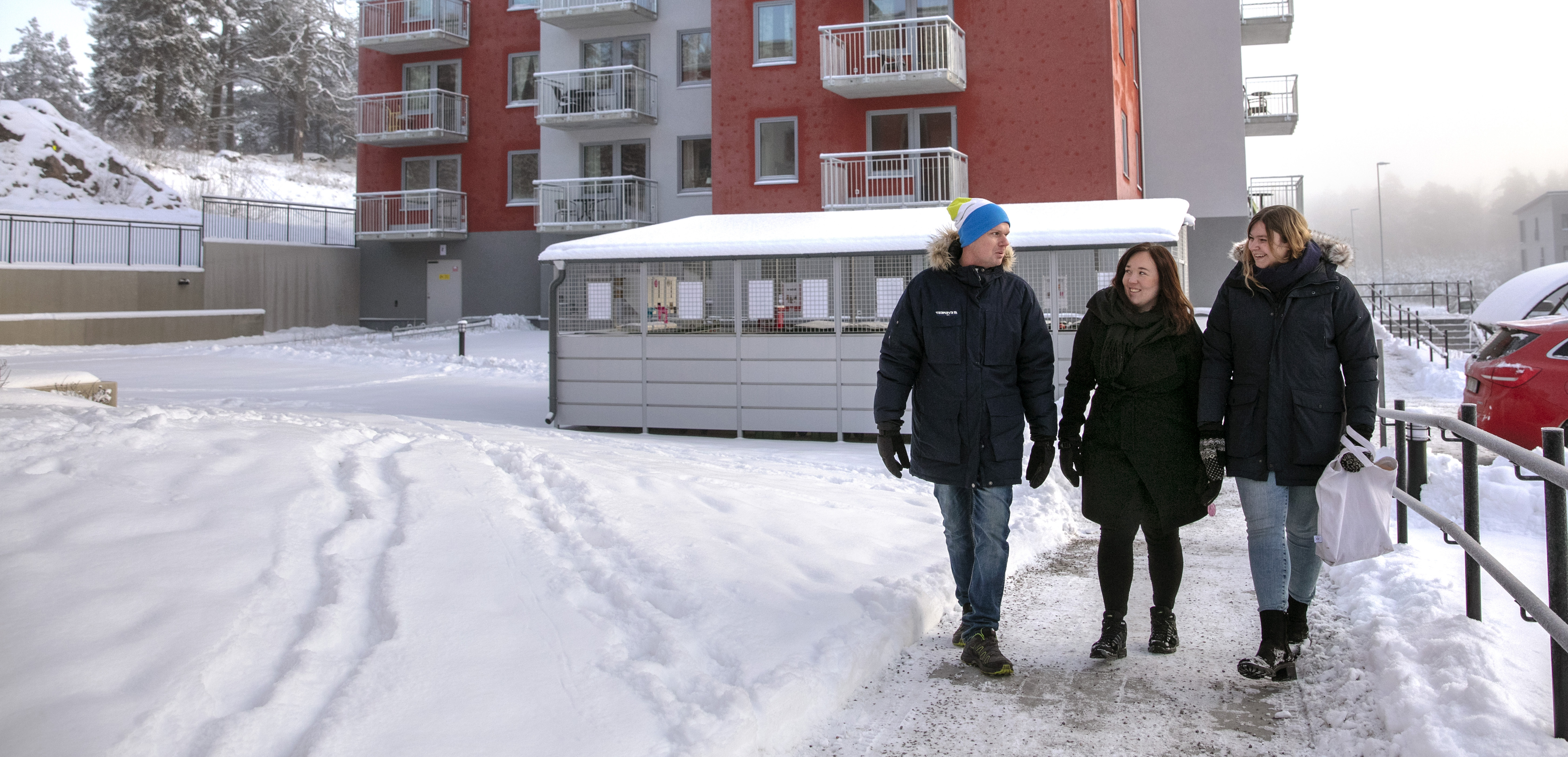 Tre personer ute och går i snön