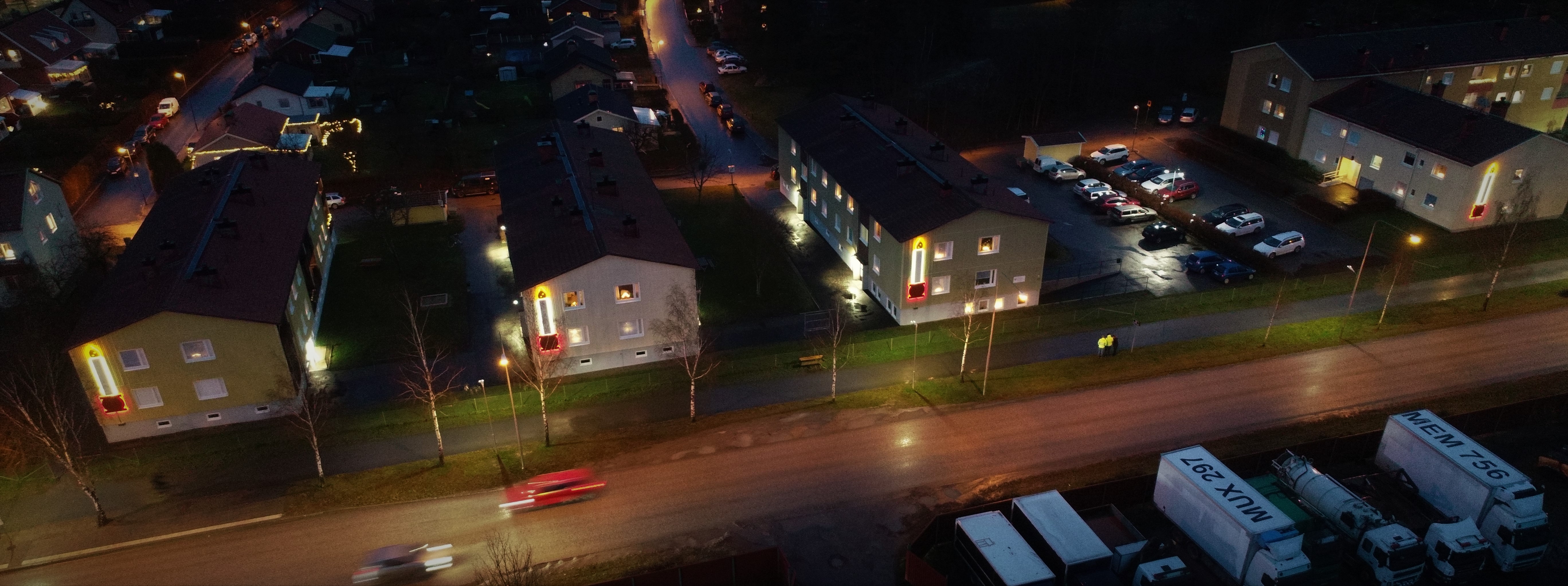 Fyra hus som bygger upp en adventsljusstake med fyra ljus