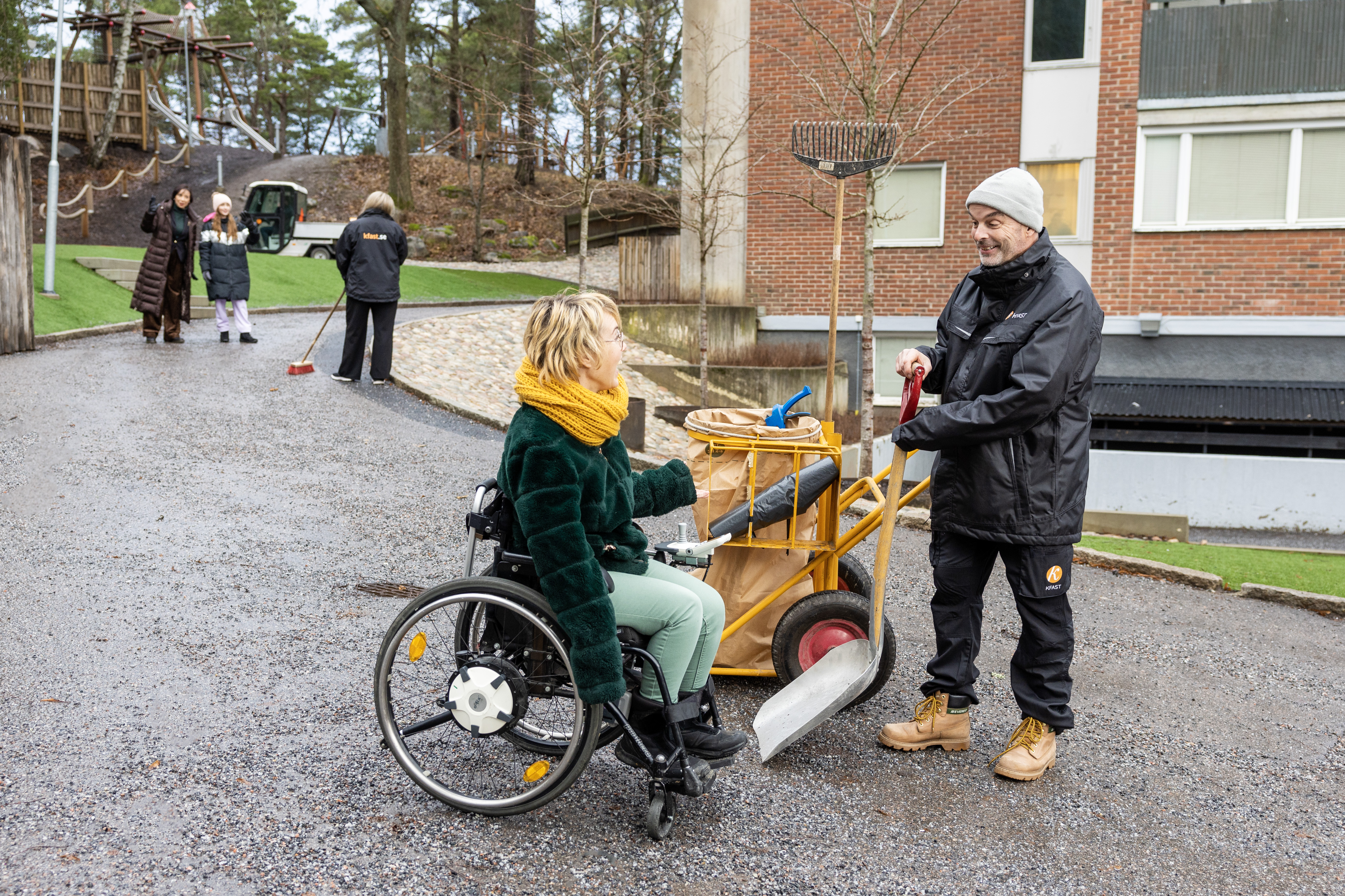 Hyresgäster och fastighetsskötare rör sig i ett bostadsområde.