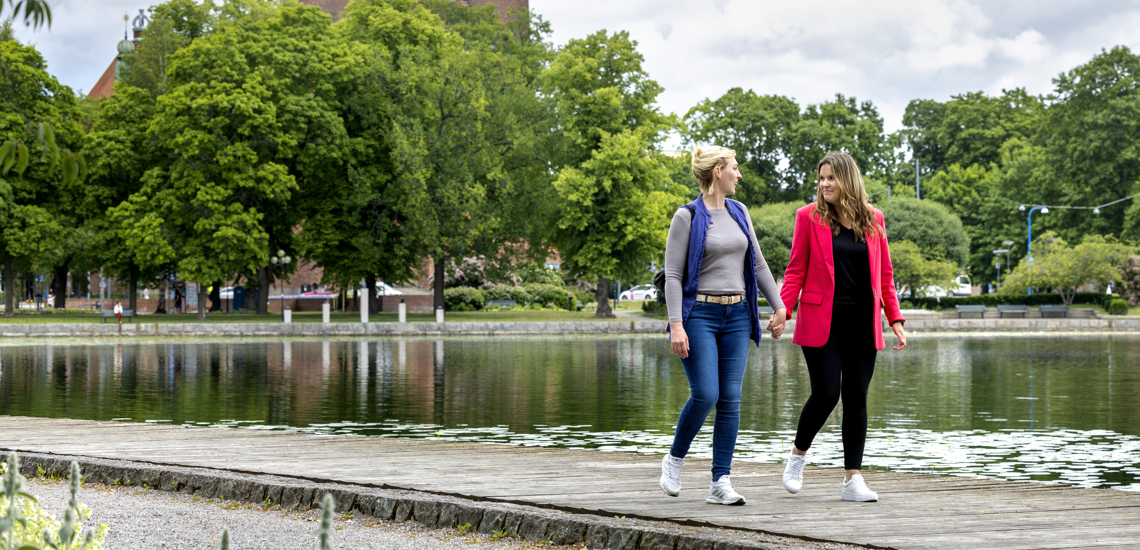 Två personer går längs vattnet tillsammans