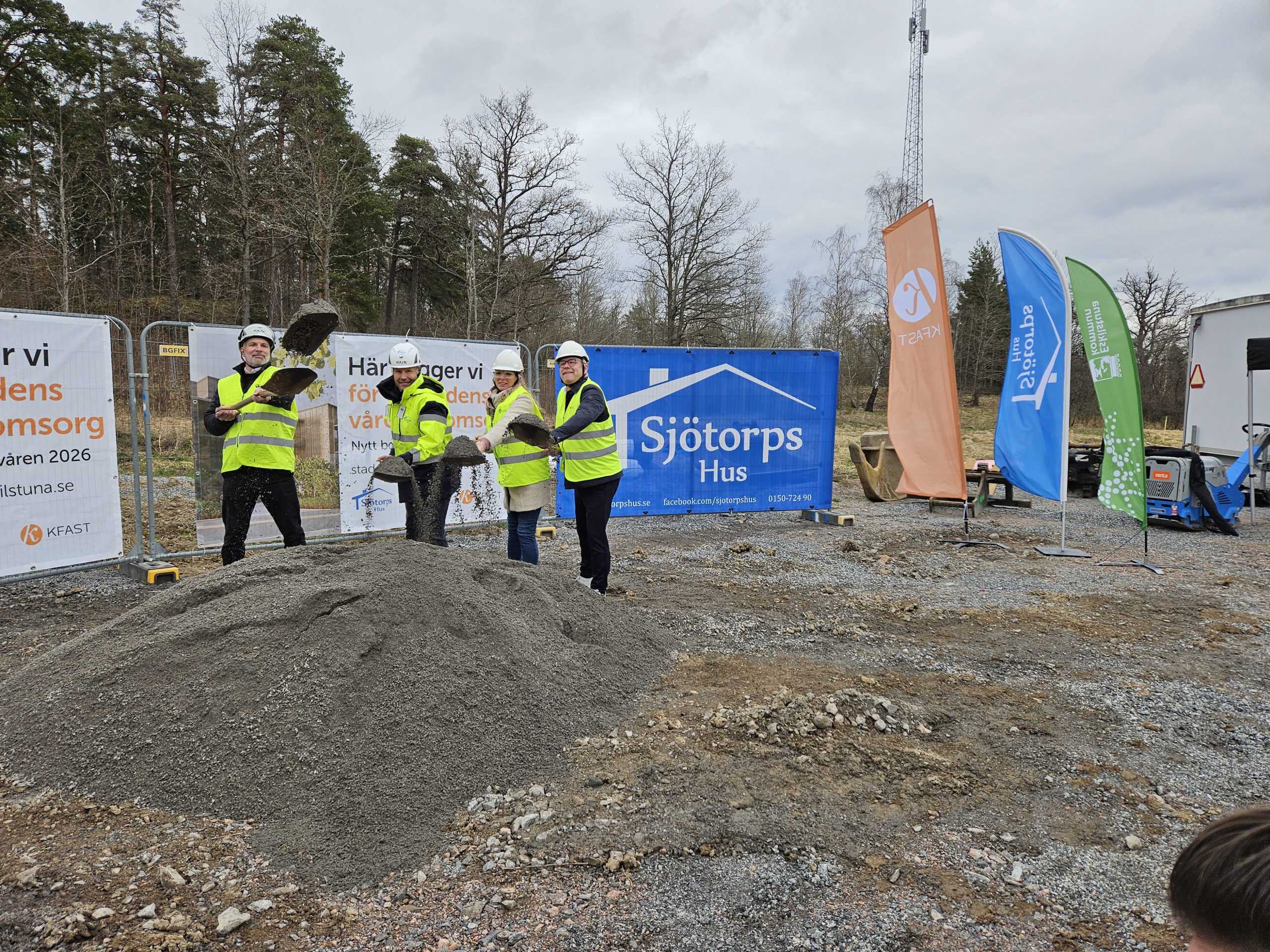 Fyra personer står med spadar i en grushög och gräver.