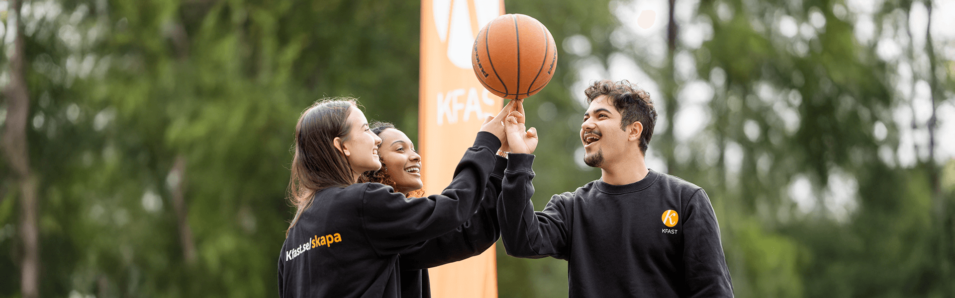 tre ungdomar som leker med en basketboll