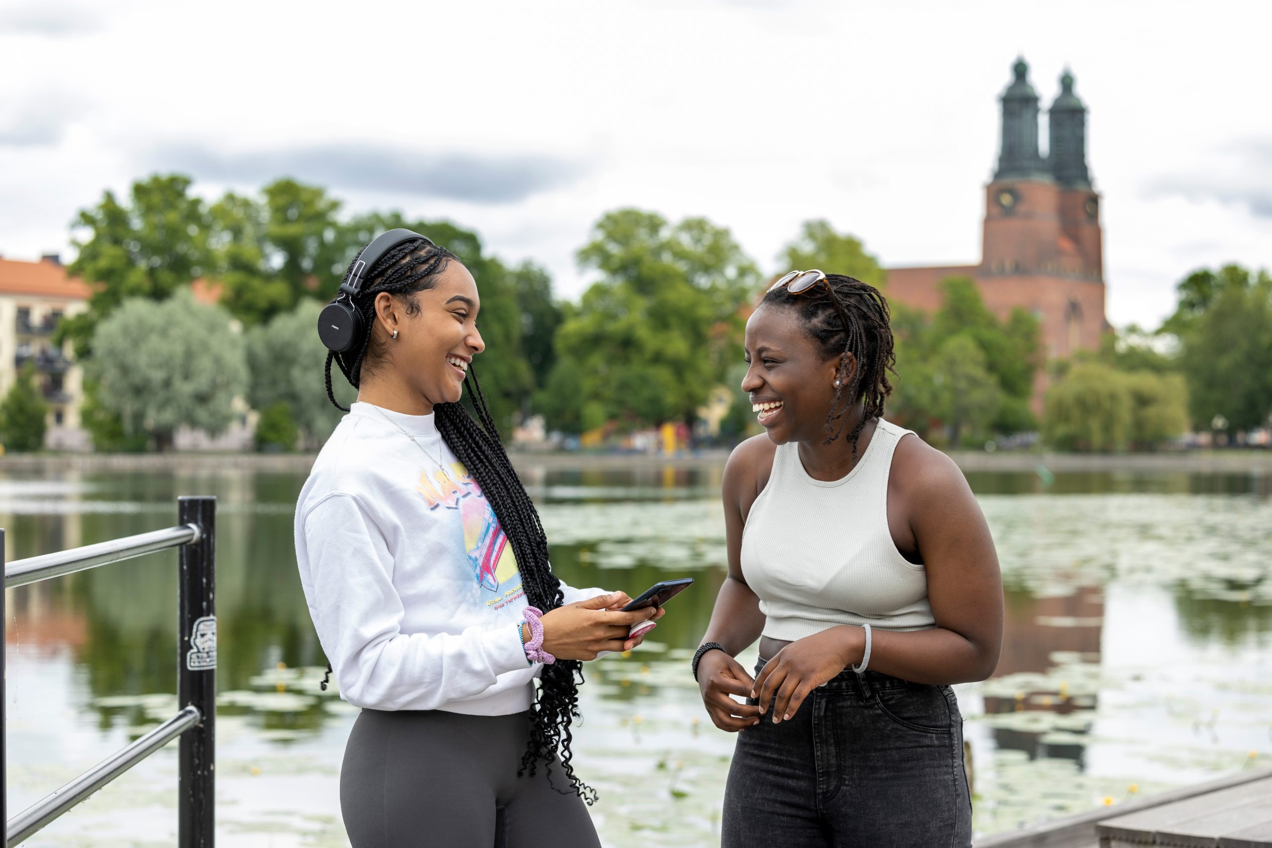 två unga kvinnor pratar glatt vid eskilstuna ån